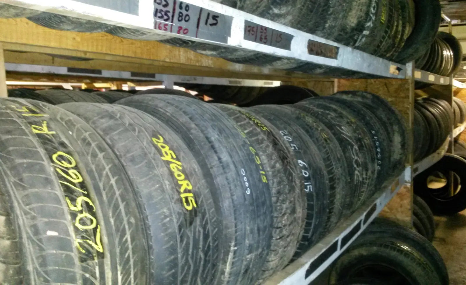 Used tires on the racks at Triangle Auto Recyclers, sizes marked on each tire